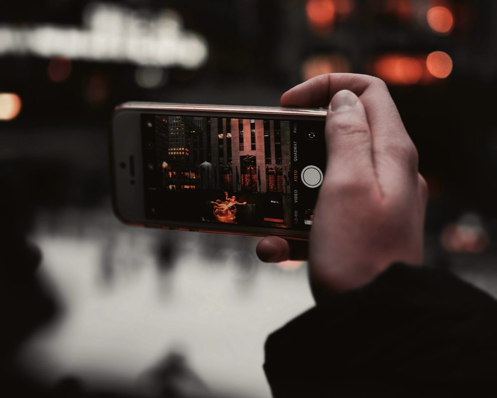 Hand holding a phone at night, send your flash